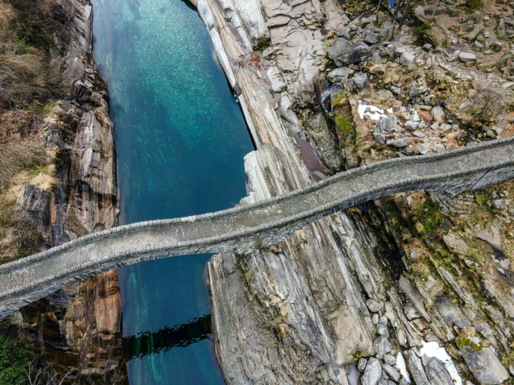 a long bridge going over the river on top of a mountain