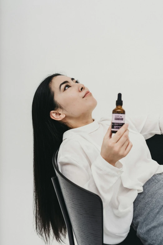 a person sitting in a chair holding a bottle