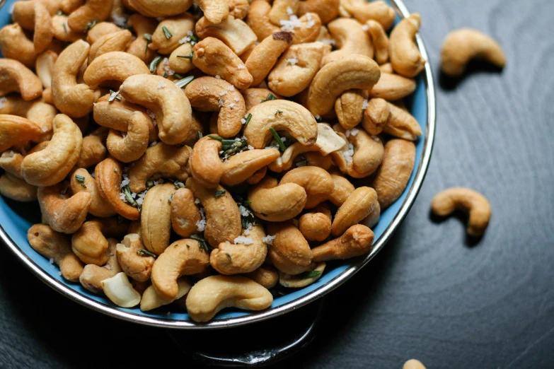 a bowl filled with cashews and topped with sea salt