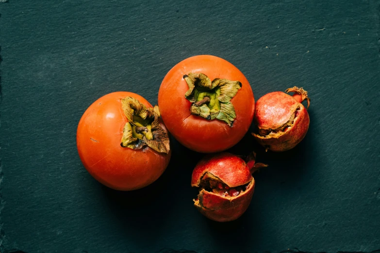 four pieces of red tomatoes on a green surface