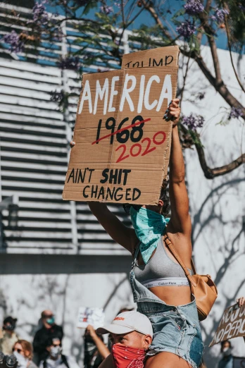 a woman is holding a sign that says, i am america