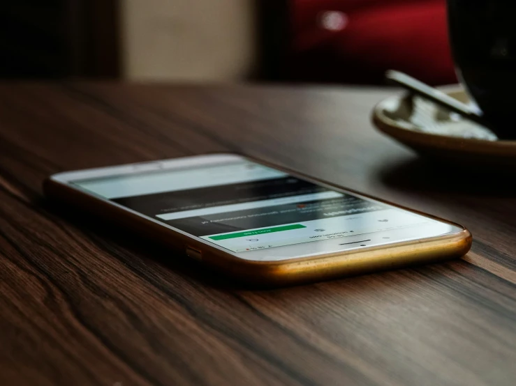 a mobile phone that is sitting on a wooden table