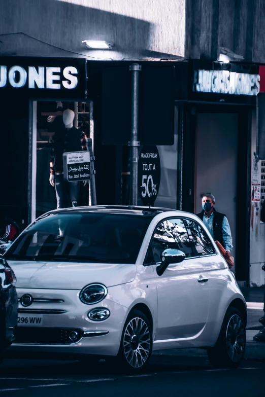 a white car parked in front of a street side shop