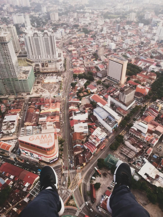 a person standing on the edge of a ledge overlooking a city