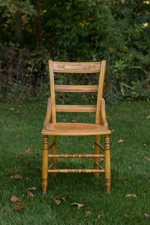 a wooden chair sitting in the grass
