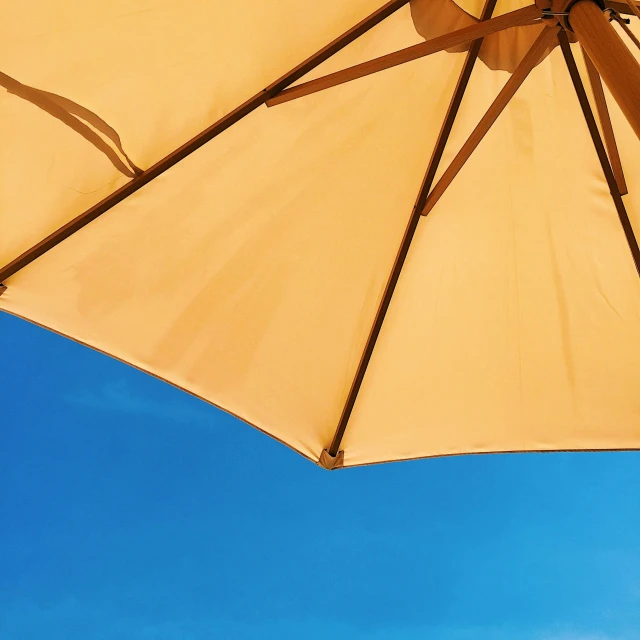 a beige umbrella is placed near the ocean
