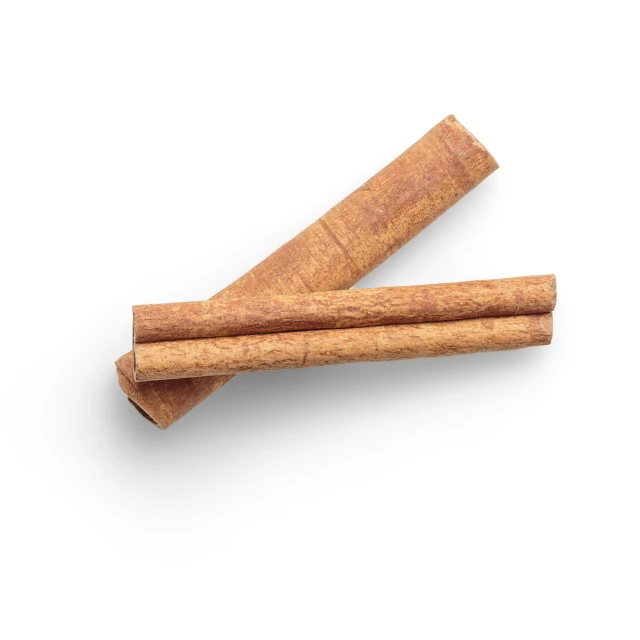 two cinnamon sticks on a white surface