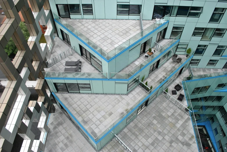 an aerial view of people sitting on benches at the end of a building