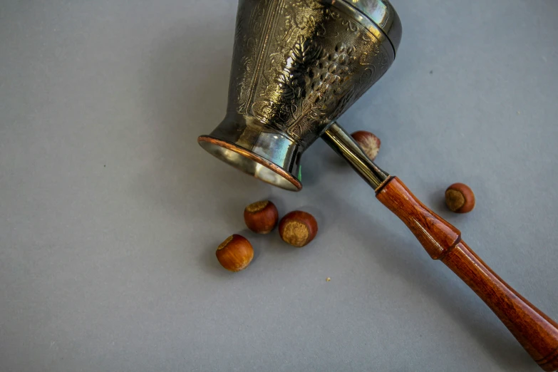 a ss metal vase with a wooden handle on top of it