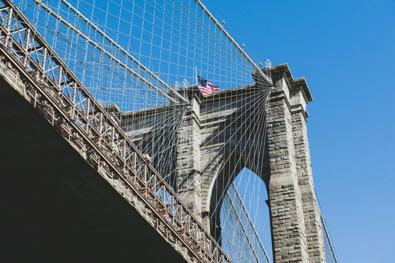 a blue sky and the underside of a bridge with a wire framework