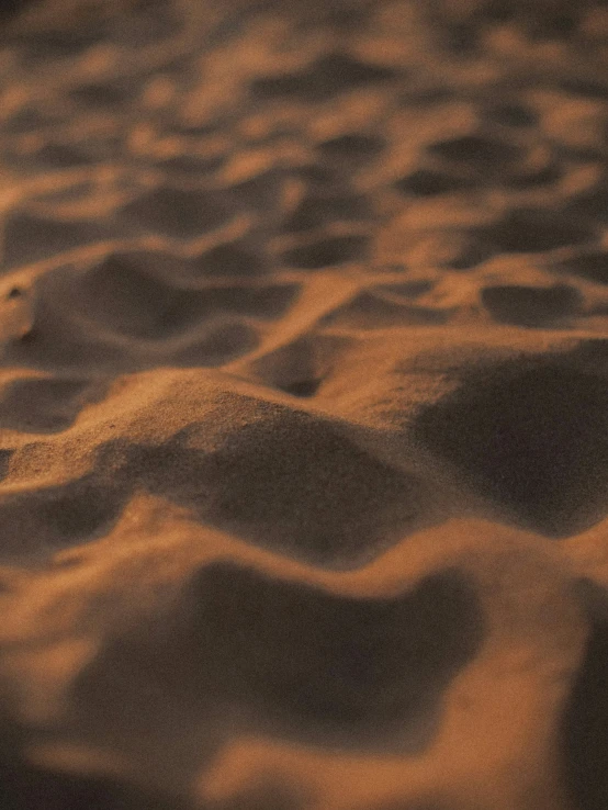 an orange substance in the sand with other sand and gravel