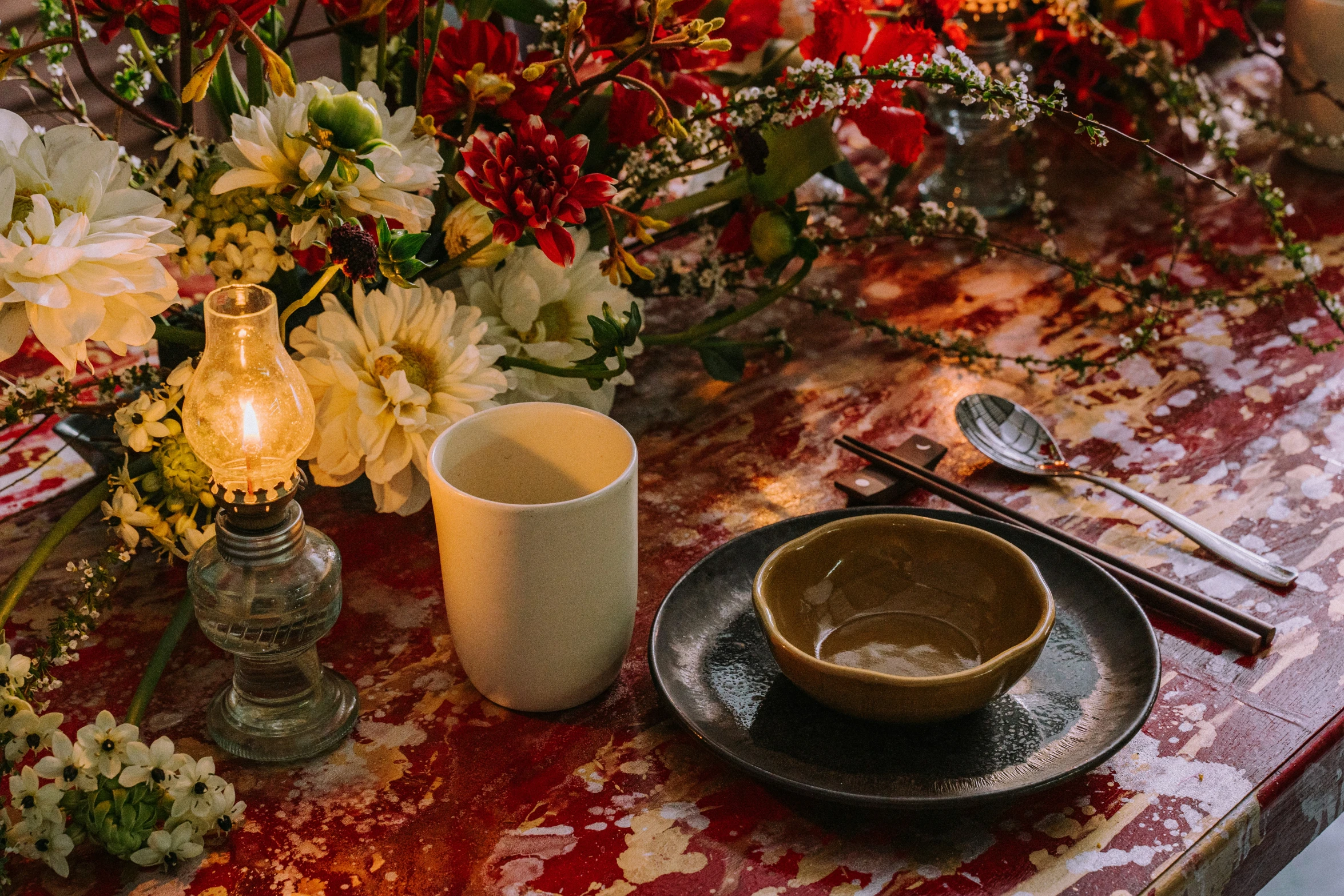 a glass of water is beside a plate with a knife