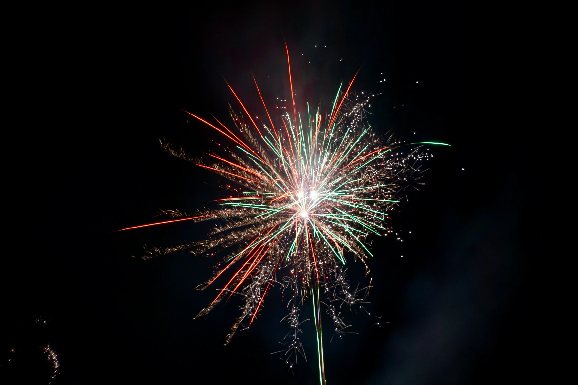 a fireworks with colorful lights is in the dark