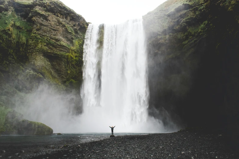 man standing by a waterfall in the middle of nowhere