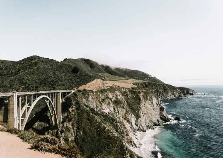 a highway over a body of water near a cliff