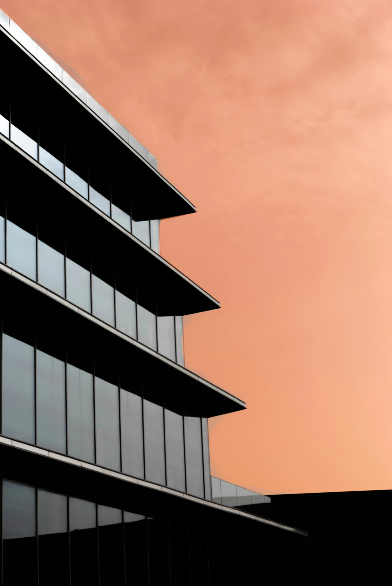 a silhouette of a high rise office building against a dusk sky