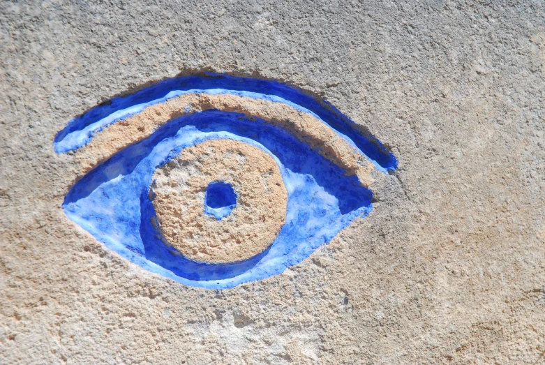 a blue eye drawn on the sand by someone