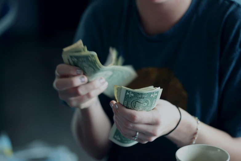 a person that is holding cash in her hands