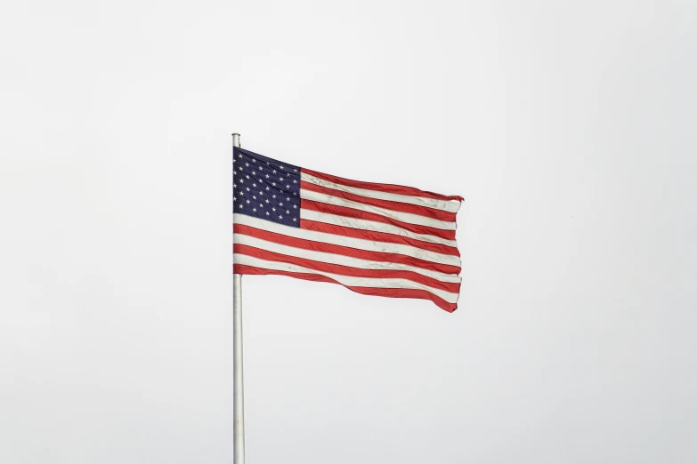 an american flag waving against a cloudless sky