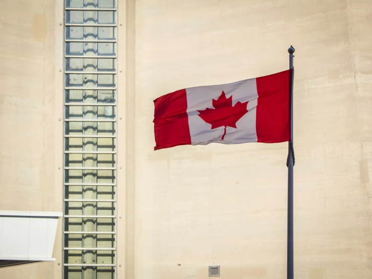 the canadian flag is in front of the building