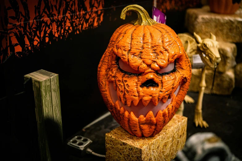 a pumpkin that is sitting on a wooden block