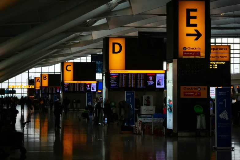 several airport departure signs in a terminal at night