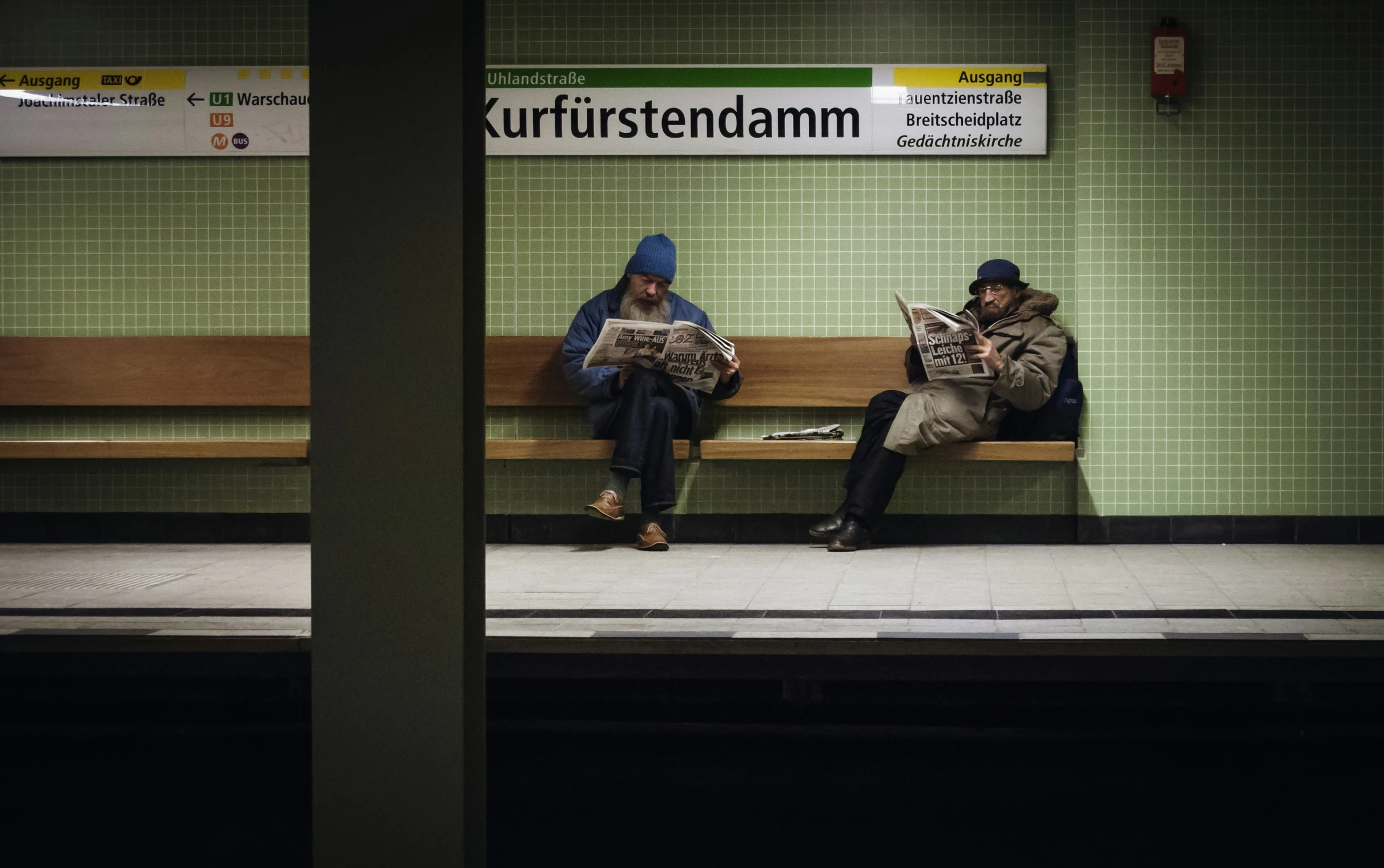 a couple of men sitting on a wooden bench