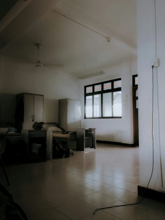 an empty room with a sink, mirror and refrigerator