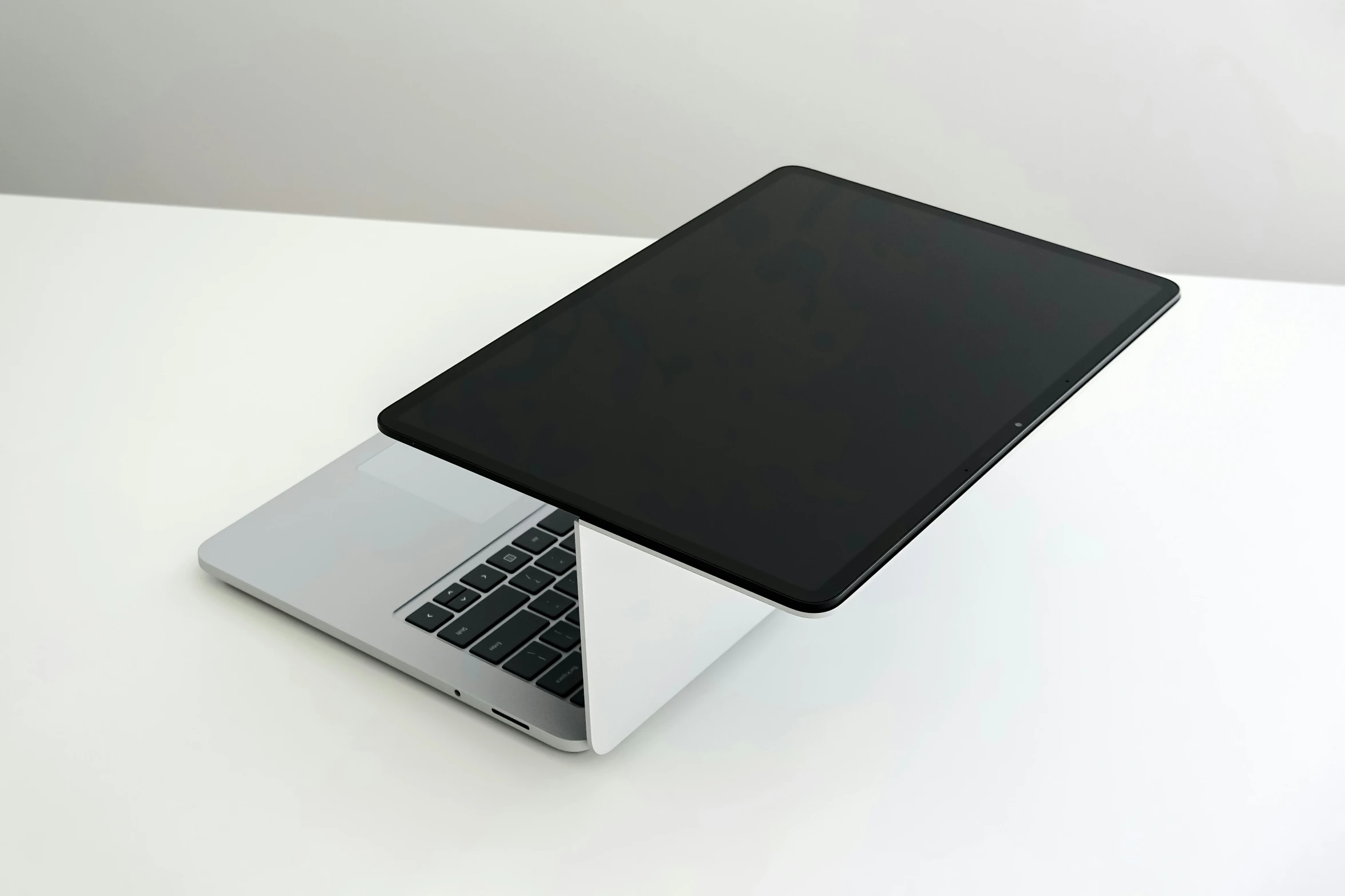 an open laptop is on the table in white