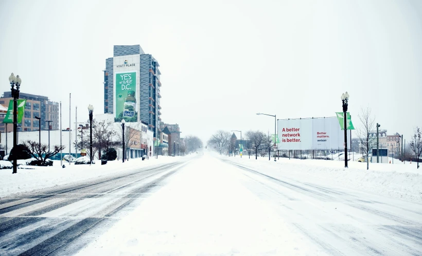 snowy street scene with traffic lights and signs