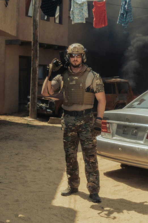 a man standing on a dirt road next to a car