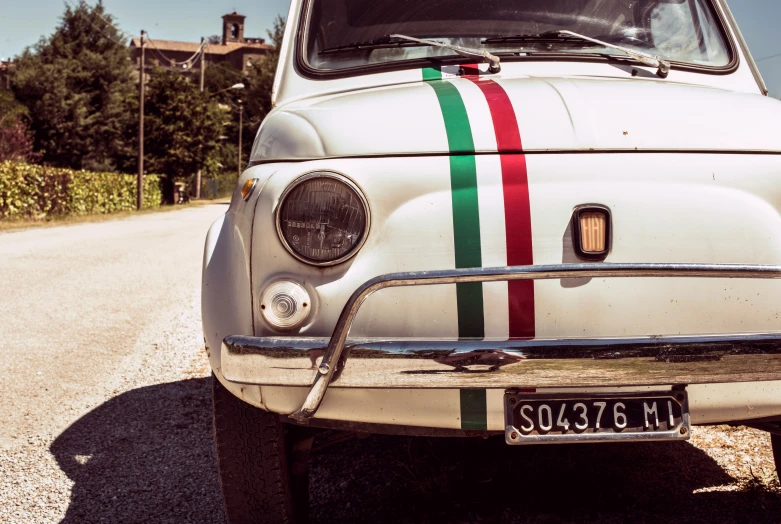 an old car painted with a bright rainbow stripe