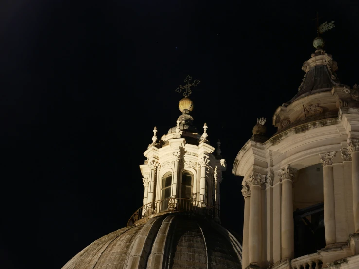 a building with domes at night with the moon visible