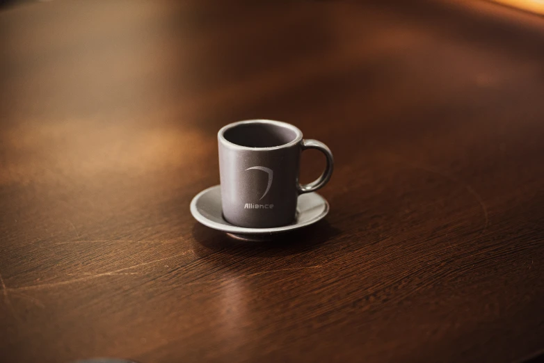 coffee cup with saucer placed on a wooden table