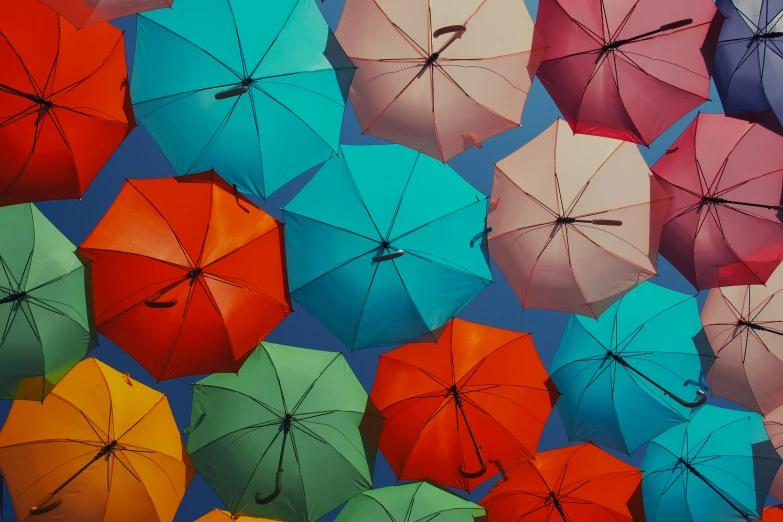 a large group of colorful umbrellas laying on top of each other