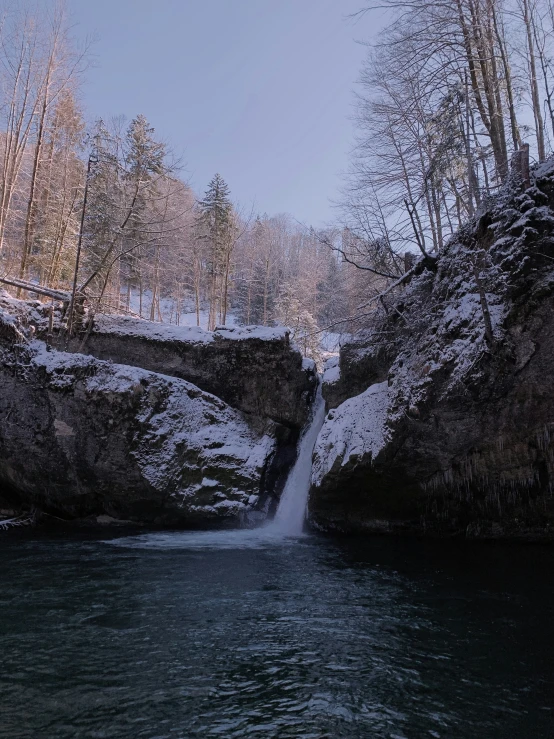 a small waterfall coming out of a big cliff