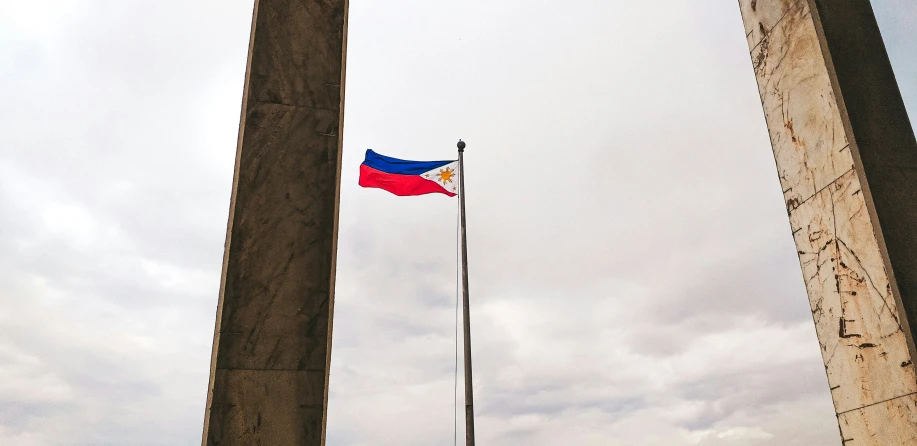 a flag flying next to the top of a stone structure