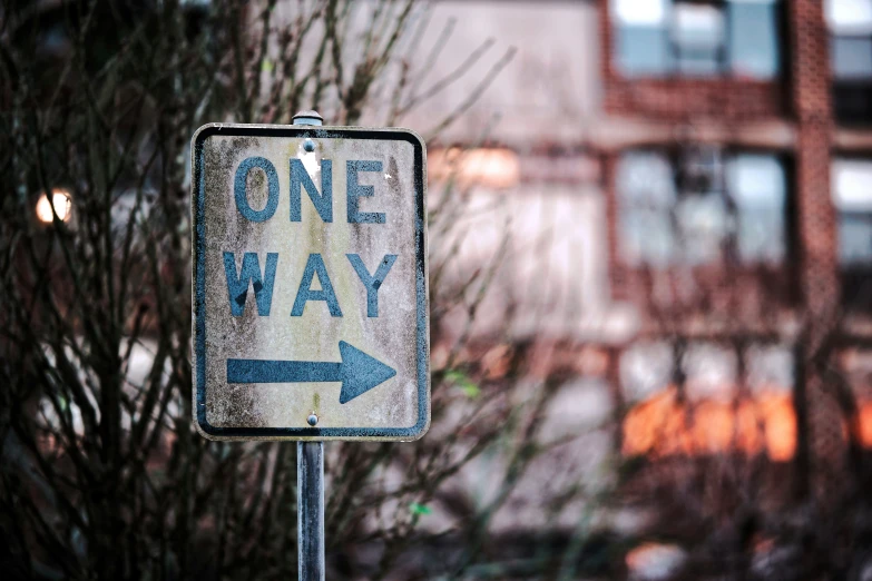 a one way sign and some nches in front of a building