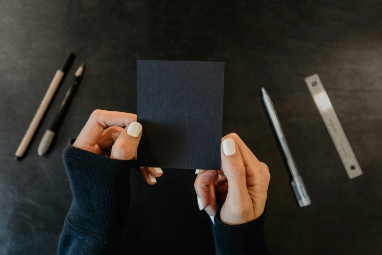 a woman holding up a piece of paper that she has made in her hands