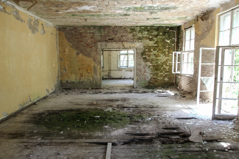 an empty room with debris on the floor and windows