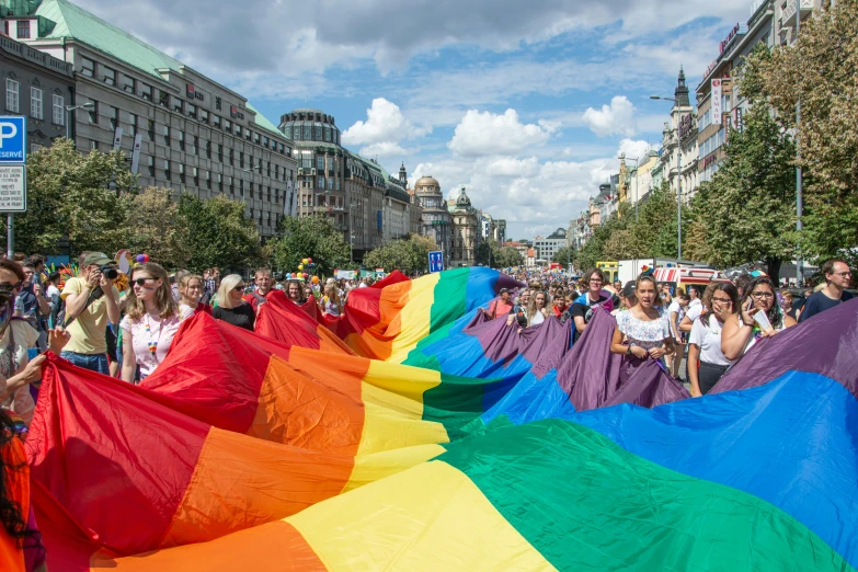 people standing in the street and one person holding rainbow flags