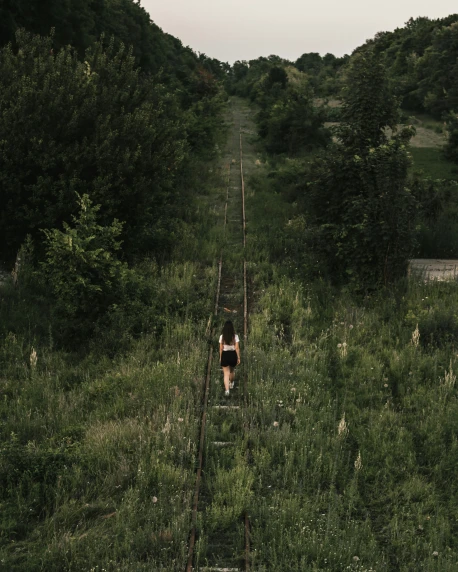 the person is walking along the railroad track