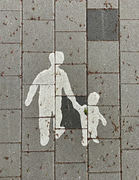 a couple walking down a sidewalk next to a street sign