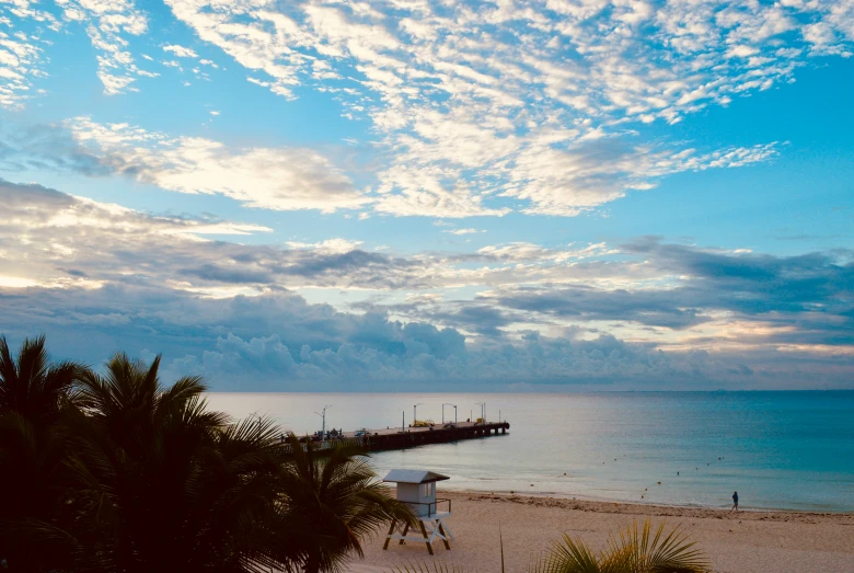 the view of a beach with a dock to the water