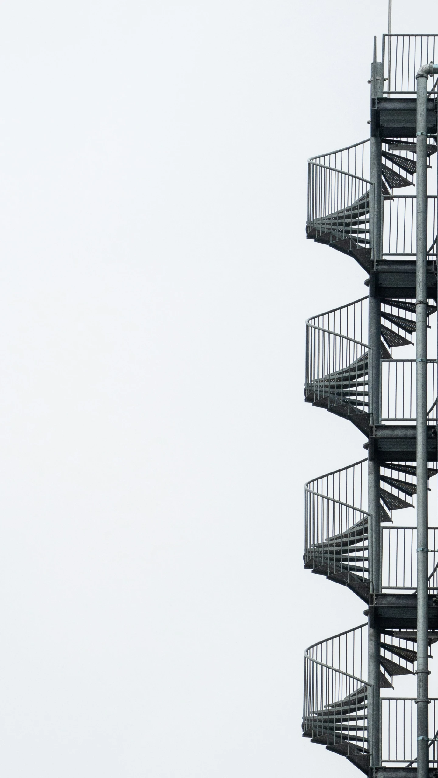 looking up at the spirally building with a white sky