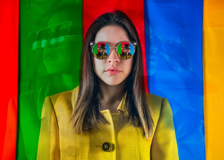 a young woman wearing sunglasses with a very colorful background