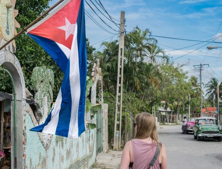 a woman looking at a flag outside in a neighborhood
