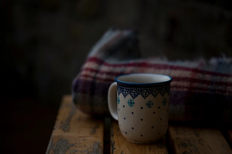 two mugs on top of a table near a blanket