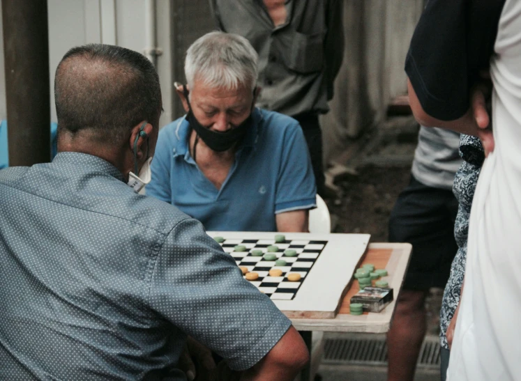 a group of people playing chess and laughing