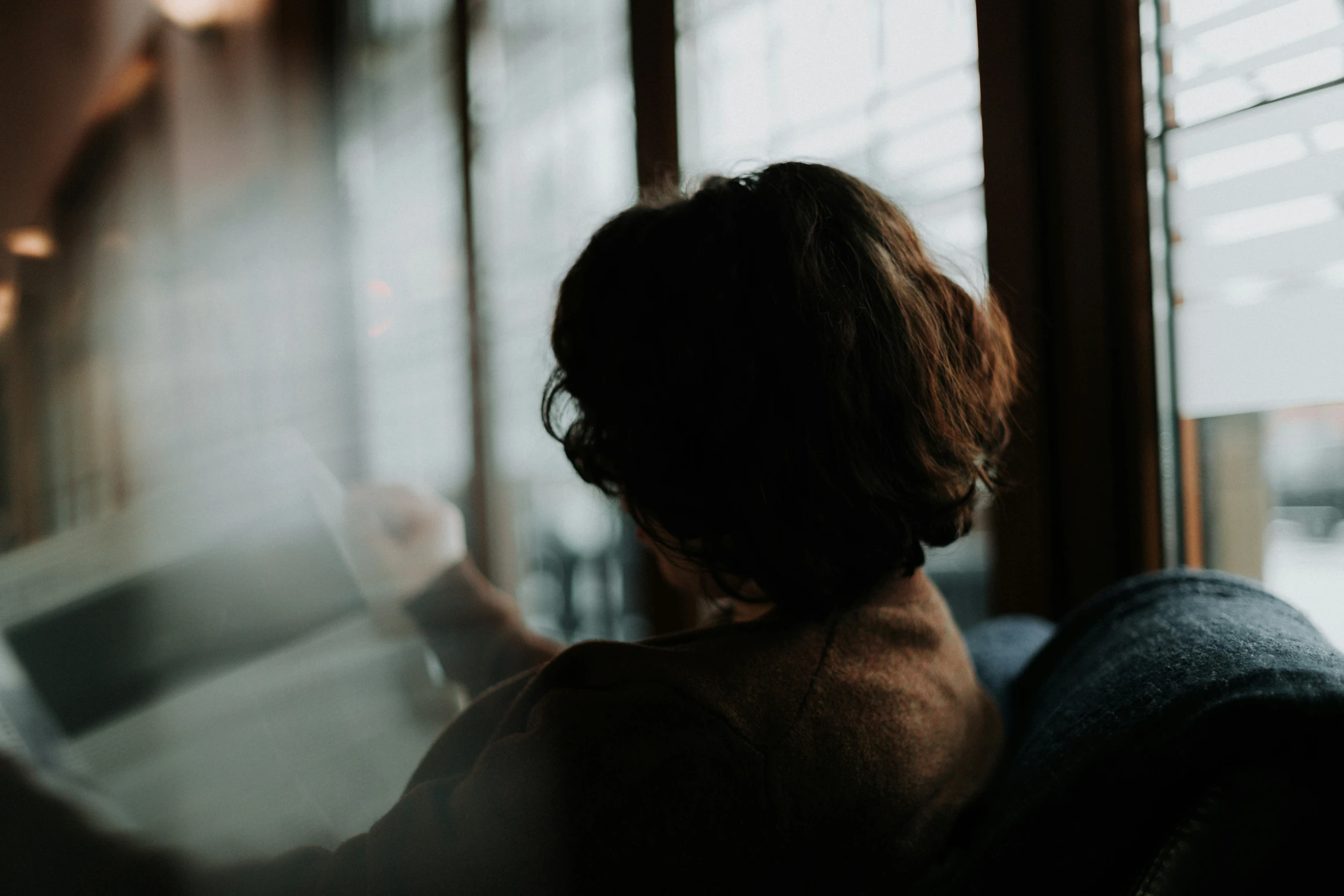 a woman is looking out the window at snow